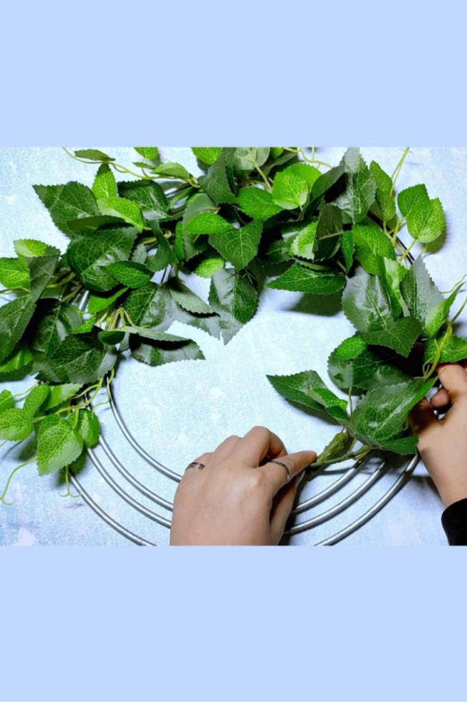 Continue until you cover the whole metal frame wreath with green leaves 