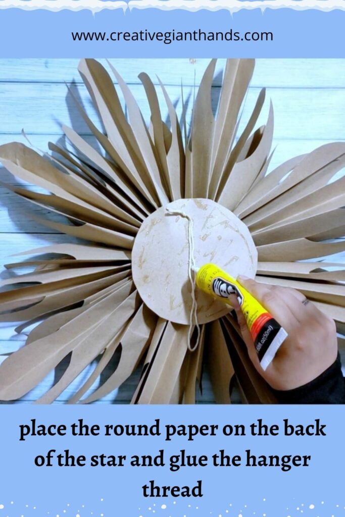 place the round paper on the back of the star and glue the hanger thread